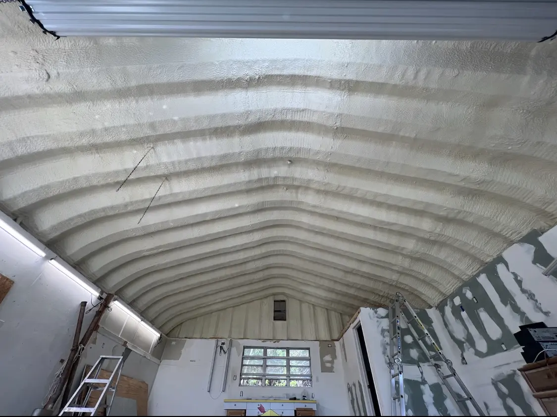 Spray polyurethane foam applied to the underside of a metal roof deck in Paola